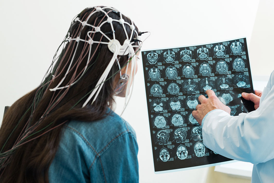 female patient receiving neurological rehabilitation treatment and looking at a brain scan at Precision Brain Center in Raleigh North Carolina